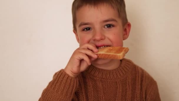Mládenec ve školce jí opečený chleba. Intolerance lepku u dětí. — Stock video