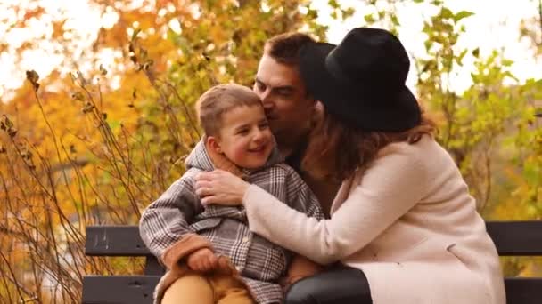 Sonbahar parkında düşen yaprakları olan genç bir aile. Aile sevgisi. — Stok video
