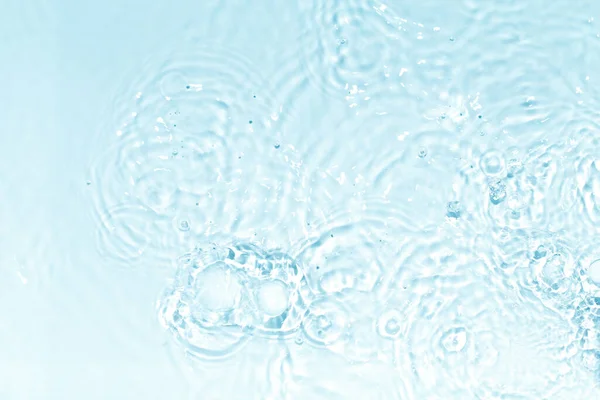 Surface d'eau bleue, transparente et claire avec éclaboussures et petites bulles. Texture d'eau. Vue rapprochée. Tendance abstraite nature fond. — Photo