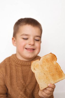 Çocuklar ve glüten. Kızarmış ekmeği olan anaokulu çocuğu. Çocukların glüten duyarlılığı. Metin veya sembol için ekmek üzerine boşluk kopyala.