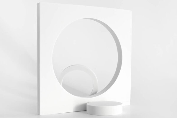 White podium on the white background, simple geometric forms. Podium for product, cosmetic presentation. Creative mock up. Pedestal or platform for beauty products.