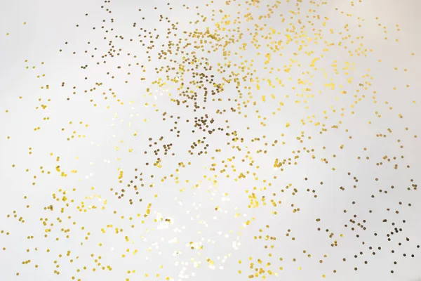 Złote konfetti brokatowe na białym tle. Błyszczące cząstki, dekoracyjne abstrakcyjne tło. Wesołych Świąt, Szczęśliwego Nowego Roku. — Zdjęcie stockowe