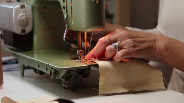 Close-up zicht op vrouwen handen naaien stof met een vintage, retro naaimachine. Mode, creatie en maatwerk. Naaiproces in atelier of werkplaats. — Stockvideo