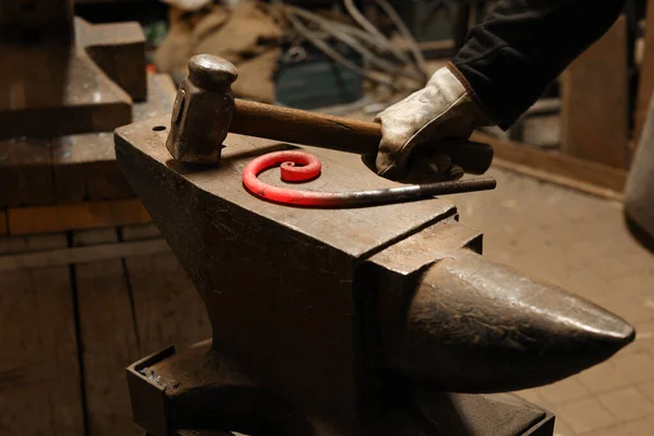 Vue rapprochée du métal chauffé et de l'enclume. Le forgeron dans le processus de production de produits métalliques fabriqués à la main dans la forge. Forge de forge de métal avec un marteau. — Photo