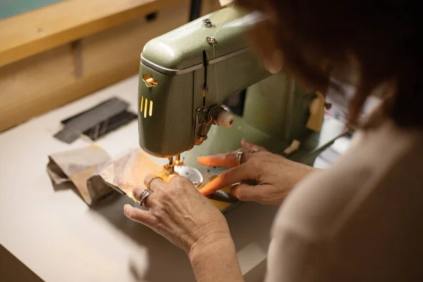 Closeup view of womans hands sewing fabric with a vintage, retro sewing machine. Fashion, creation and tailoring. Process of sewing in atelier or workshop. — Stock Photo, Image