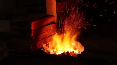 Demircide çalışan demirci, ateşte ısıtan metal. Demirciden metal eşyalar yapmak. Alevler içindeki kızgın demir parçası.