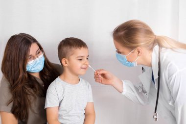 Covid 19 çocuk testi. Doktor ya da hemşire geniz temizleme yöntemi kullanarak küçük çocuğa koronavirüs testi yapıyor. Risk ve enfeksiyon kontrol konsepti. Çocukların sağlığı.