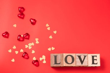 Küplerde aşk mesajı, kalpler ve kırmızı arka planda konfeti. Sevgililer Günü. Kartpostal, tebrik kartı tasarımı. Aşk, kutlama konsepti. Metin için boş alan, kopyalama alanı.