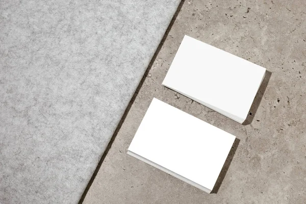 Blank white business cards on rough concrete surface. Mockup for branding identity. Two stacks, to show both sides of card. Template for graphic designers. Free space, copy space. — Foto de Stock