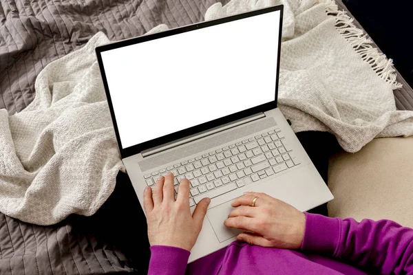 Man relaxing on bed and holding laptop computer. Mock up with blank white screen. Man using notebook to surf in internet, read news, watch movie, study or work online. App, game, web site presentation — Stock fotografie