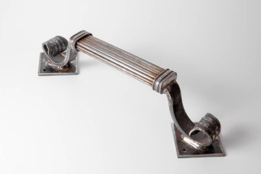 Demirciden yapılmış özel bir kapı kolu. Sahte, el yapımı saplı. Yakın çekim görüntüsü. Sahte üretim. Metalden mimari ayrıntı, beyaz arkaplanda demir..