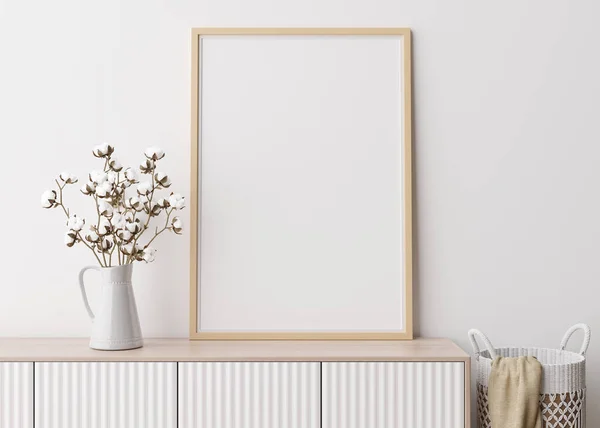 Empty vertical picture frame on white wall in modern living room. Mock up interior in minimalist, scandinavian style. Free space for picture. Console, rattan basket, cotton plant in vase. 3D rendering