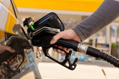 Benzin istasyonunda yakıt ikmali. Adam arabaya yakıt dolduruyor. Manzarayı kapat. Benzin, dizel daha pahalı hale geliyor. Petrol endüstrisi ve hizmet. Petrol fiyatı ve petrol krizi kavramı.