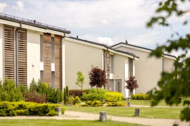 Modern kulübelerden oluşan bir sıra. Gıcır gıcır bekar aile evleri. Özel bahçeli kentsel konutların modern tasarımı, sofistike sonlar. Yeni bir gelişme. Yeşil açık hava tesisleri, çimenler.