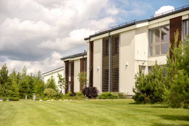 Modern kulübelerden oluşan bir sıra. Gıcır gıcır bekar aile evleri. Özel bahçeli kentsel konutların modern tasarımı, sofistike sonlar. Yeni bir gelişme. Yeşil açık hava tesisleri, çimenler.