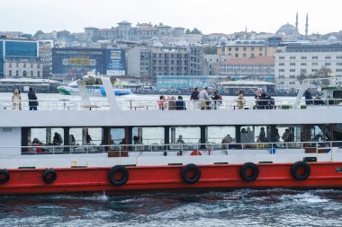 İstanbul, Türkiye, 13 Ekim 2021: Zevk gemisi sonbahar günü turistleri İstanbul Boğazı 'na götürüyor. Arka planda, ünlü eski camileriyle İstanbul kenti görülüyor.