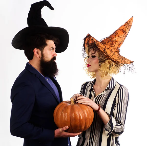 Halloween couple in witches hats with pumpkin. Magic for Halloween. Preparation Halloween holidays. Jack-o-lantern.