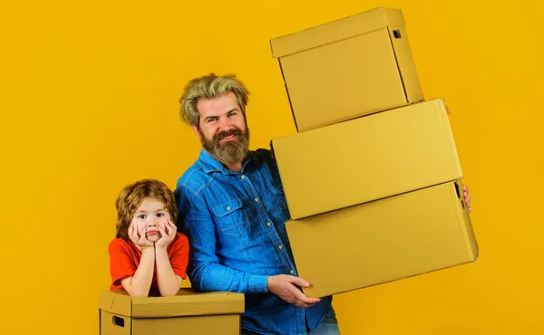 父亲和儿子与纸箱。准备出发吧家庭和新家庭概念。包装东西. — 图库照片