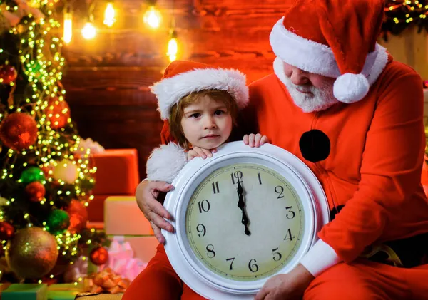 Рождество или Новый год. Маленький Санта-помощник и Санта-Клаус со старыми часами. Новую полночь. Рождественские украшения. — стоковое фото