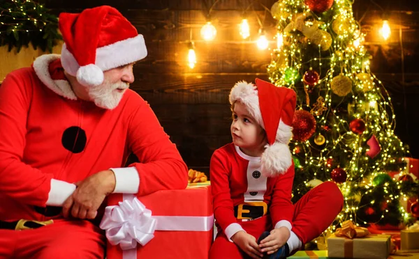 Санта Клаус и маленький мальчик Санта с рождественским подарком. Семейный отдых. Рождественские подарки С Новым годом. — стоковое фото