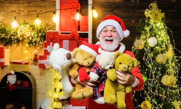 Санта Клаус с плюшевыми мишками. Бородатый мужчина в костюме Санты с плюшевыми игрушками. Подарки милым детям. Рождество и новогоднее украшение. — стоковое фото