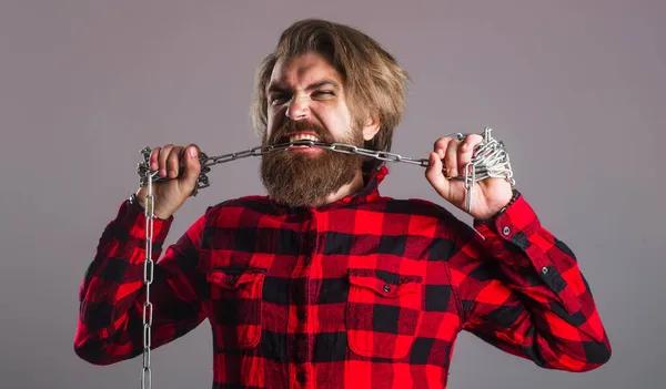 Man tearing Metal chain by teeth. Freedom. Bearded hipster break chain. Strong man with chains. Male fashion. — Stock Photo, Image