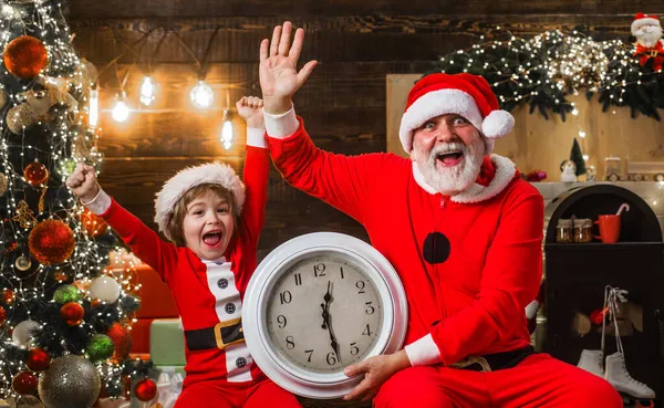 Санта-Клаус и маленький помощник с часами, размахивая рукой и празднуя Новый год. Время Рождества. — стоковое фото