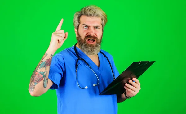Dokter profesional dengan papan klip yang menunjuk ke atas. Terapis serius dengan stetoskop memegang folder. Sejarah dan resep medis. — Stok Foto