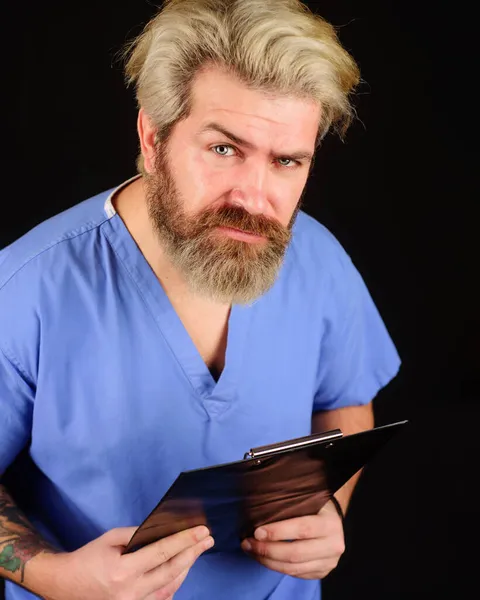 Dokter profesional berseragam dengan clipboard. Perawat pria berjanggut dengan folder di rumah sakit. Riwayat atau resep medis. — Stok Foto