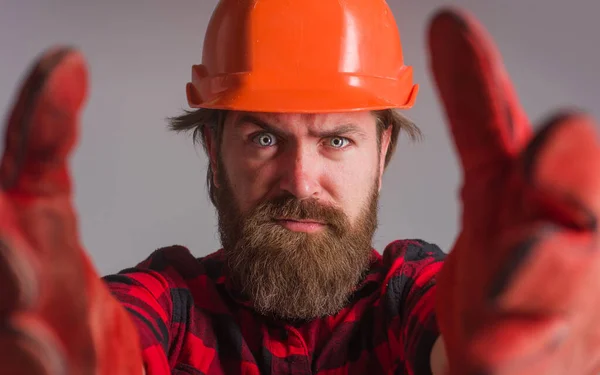 戴头盔的建设者戴着硬礼帽和工作手套的工人.建筑，工业，技术。有胡子的工人服装。有选择的重点. — 图库照片