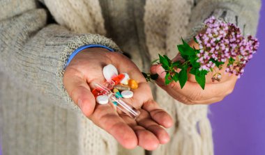 Haplı ve bitkisel bitkilerle dolu bir erkek eli. Doğal bitkiler. Homeopati, naturopati. Alternatif tıp.