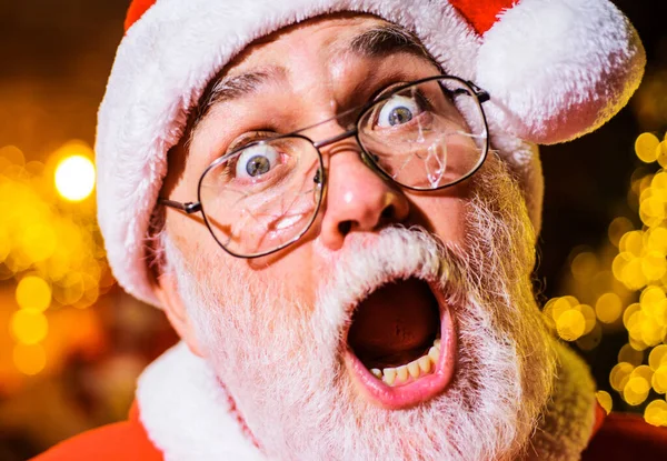 Zaskoczony Święty Mikołaj w stłuczonych okularach. Człowiek z brodą w pękniętych okularach. Wesołych Świąt. Szczęśliwego Nowego Roku. — Zdjęcie stockowe