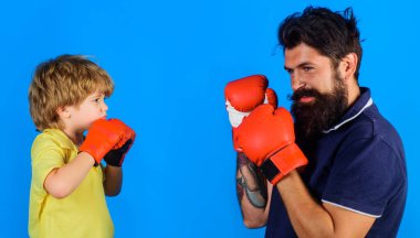Koçla boks eldiveni eğitimi almış bir çocuk. Eğitmen çocuk. Babası ve oğlu birlikte boks yapıyor..