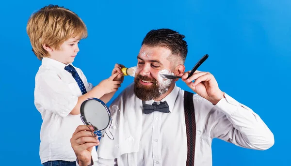 爸爸和儿子在理发店。胡子在乎。理发店和理发店。个人造型师爸爸的助理. — 图库照片