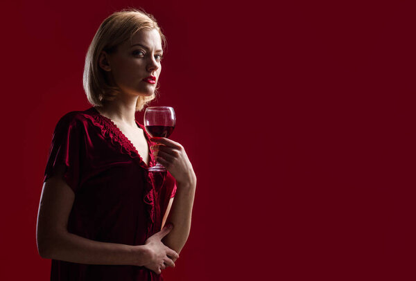 Alcohol. Sexy woman with glass of red wine. Sensual girl with wineglass. Advertising for restaurant. Copy space.