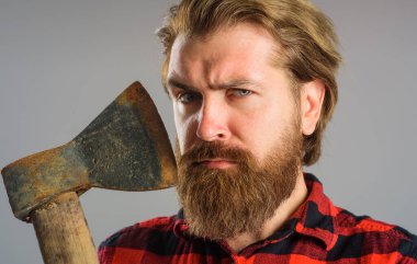 Büyük baltalı sakallı adam. Ciddi bir oduncu. Baltalı yakışıklı hippinin yakın plan portresi..