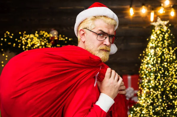 Санта Клаус носит красную сумку с подарками. Доставка рождественских подарков. Новогодняя реклама. — стоковое фото