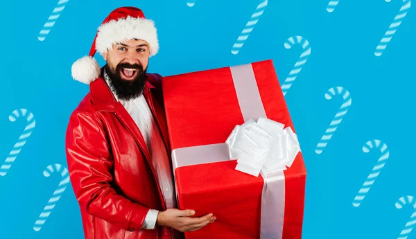 Рождественский Санта с большой коробкой подарков. Доставка подарков. Бородатый мужчина в шляпе Санты с новогодним подарком. — стоковое фото
