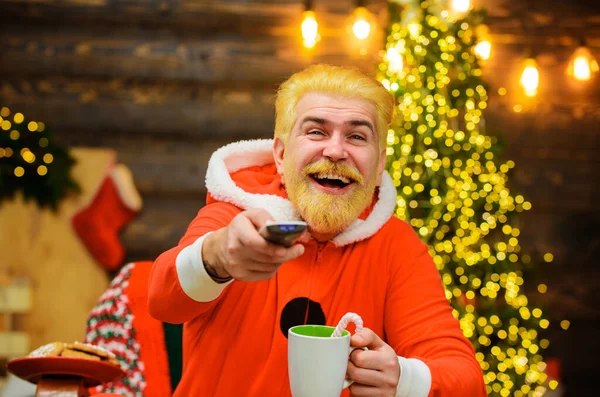 Счастливого Санта-Клауса с горячим напитком смотреть рождественский фильм. Развлечения и кино. Новогодний фон. — стоковое фото
