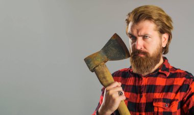 Yaşlı baltası olan yakışıklı adam. Sakallı oduncu. Baltalı, kareli gömlekli, ciddi bir erkek. Boşluğu kopyala.