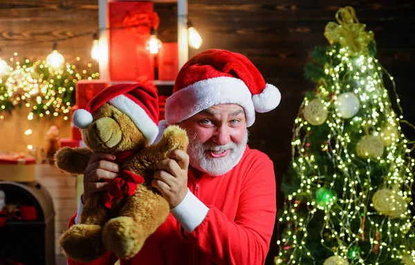 Férias de Natal. Pai Natal com ursinho de peluche. Homem barbudo em traje de Papai Noel com brinquedo de pelúcia. Ano Novo. — Fotografia de Stock