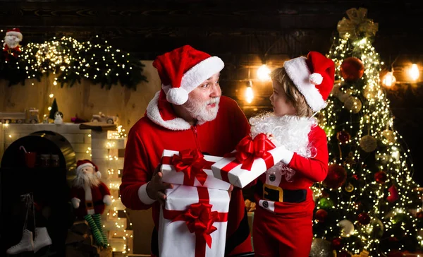 Санта Клаус и маленький помощник с рождественским подарком. Семейный отдых. С Новым годом и Рождеством!. — стоковое фото