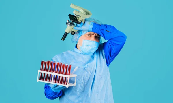 Doctor in Medical mask with Blood sample and microscope. Tired scientist with test tubes in laboratory. — 图库照片