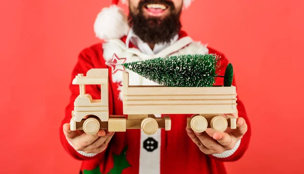 Mikołaj z choinką na drewnianym samochodziku. Dostawa, Boże Narodzenie, Nowy Rok. Skupienie selektywne. — Zdjęcie stockowe