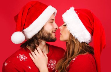 Noel şapkalı yeni yıl çifti sarılıp öpüşüyor. Romantik İlişkiler. Aşk konsepti.