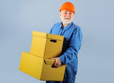 Sevkiyat. Karton kutularla gülümseyen adam. Teslimat servisi. Karton kutulu sakallı erkek kurye..