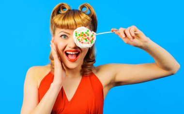 Lolipopu olan gülümseyen kız. Renkli şekerleri olan seksi bir kadın. Abur cubur, tatlı yemek, diyet konsepti..