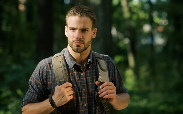 Utazás, kaland, nyaralás. Egy férfi hátizsákkal az erdőben túrázik. Szakállas hipster utazik az erdőben. — Stock Fotó
