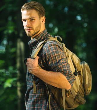 Sırt çantalı, ormanda yürüyüş yapan sakallı bir adam. Erkek, güneşli bir günde ormanda seyahat ediyor. Sağlıklı yaşam tarzı.