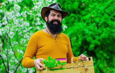 Çiftçi ekime hazırlanıyor. Baharın baharı bahçede geçer. Bahçe aletleri ile mutlu sakallı adam.